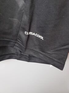 Close-up of black athletic fabric with the white 'CLIMACOOL' logo along a seam.