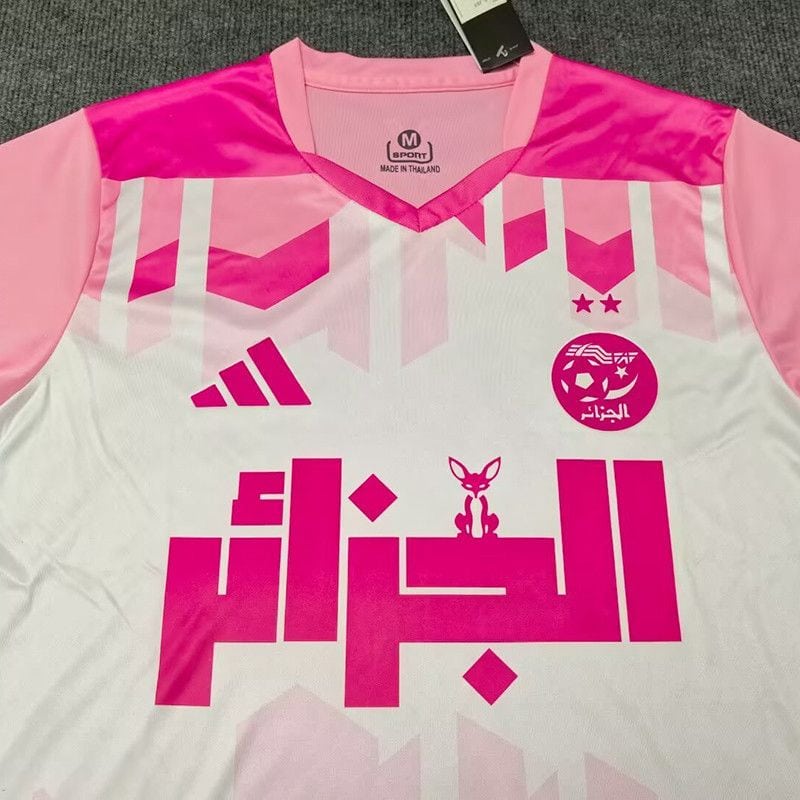 92329882-4a36-407e-a3c4-0ffdf437159c | UAE SPORT STORE Pink and white athletic jersey with geometric pink accents, large Arabic script across chest, and a small bunny crest near the center.