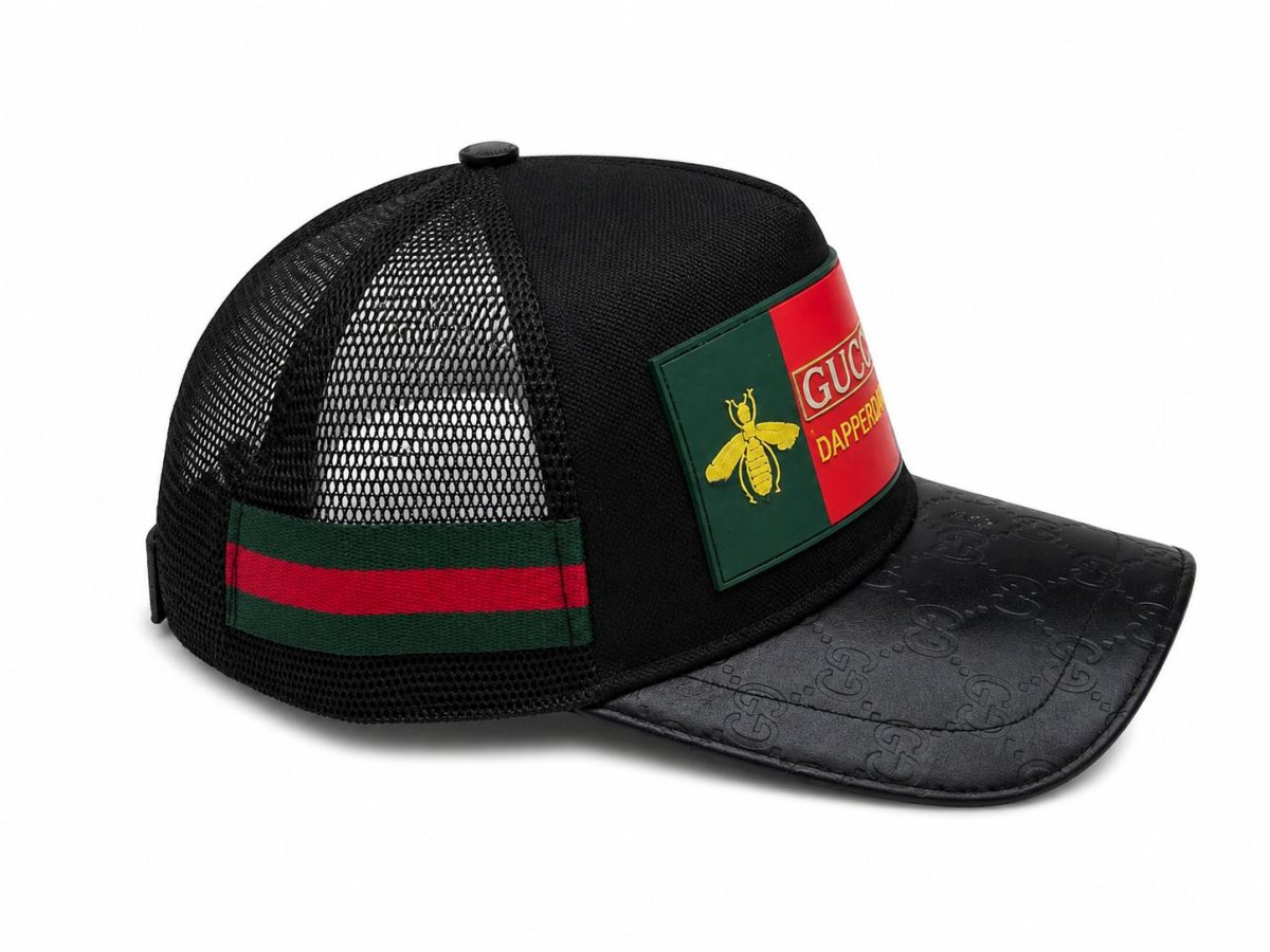 Black mesh trucker cap with a Gucci patch on the front and a red‑green side band.