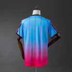 92b91cae | UAE SPORT STORE Back view of a blue-to-pink gradient sports jersey with pink vertical stripes and yellow text near the collar that reads, "i thought it was love."