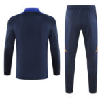 Navy blue athletic tracksuit top and matching pants shown from the back, with subtle orange accents on the knees/cides for a sporty set.