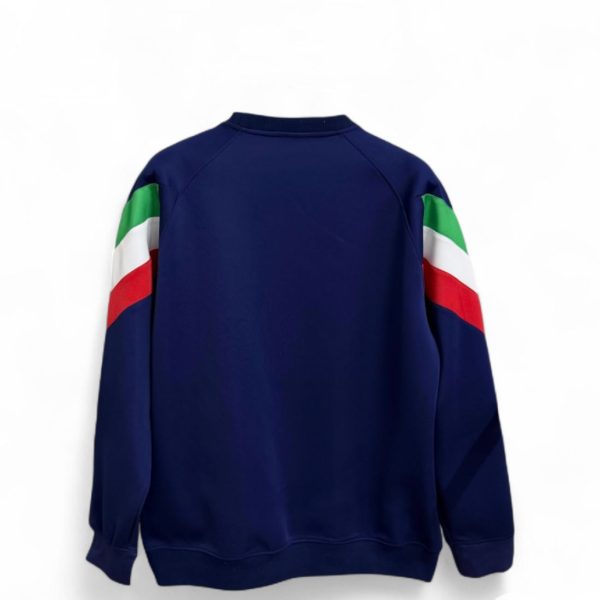 Back view of a navy sweatshirt with green, white, and red color-blocked sleeves.