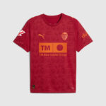 Red Valencia CF soccer jersey with orange TM Real Estate Group sponsor across the chest and Valencia crest on the left chest.