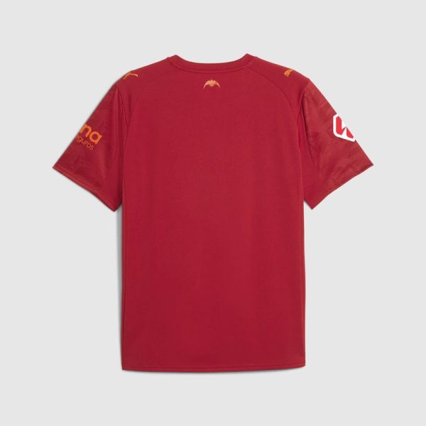 Back view of a red sports jersey with logos on the sleeves and shoulders, plain in the center.
