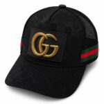 Black Gucci cap with a gold GG emblem on a patch, featuring a red-green side stripe and mesh back panel.