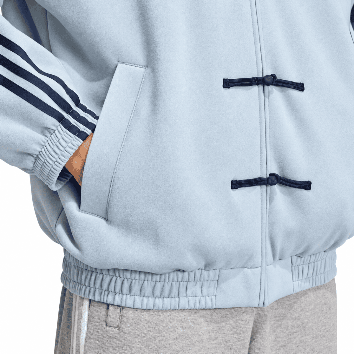 Light grey casual jacket with navy toggle buttons and side pocket.