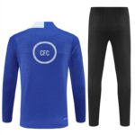 Back view of a cobalt blue long-sleeve sports jersey with a white circular 'CFC' logo, paired with black athletic pants.