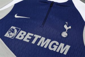 Blue Tottenham Hotspur football jersey featuring BetMGM sponsor logo, club crest, and Nike swoosh.