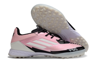 Pink soccer cleat with white three-stripe design and black laces, showing a studded sole for firm ground play.