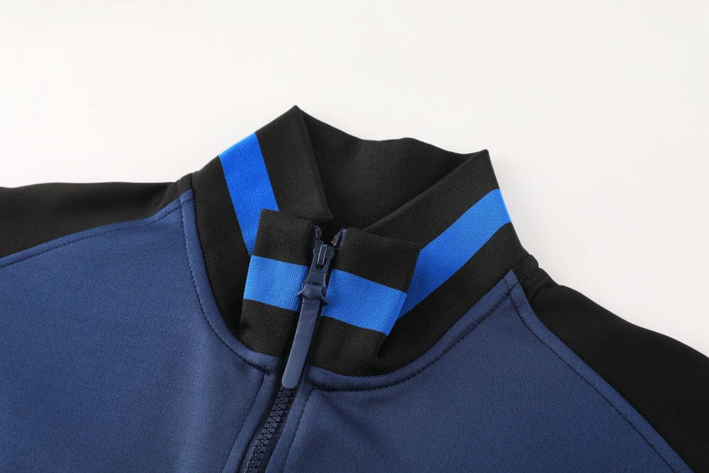97119eb1 | UAE SPORT STORE Close-up of a blue zip-front jacket showing a black and blue striped ribbed collar.