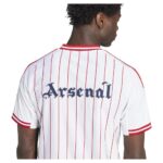 99f3c85e-5312-4087-8eaf-5c7e37ed74ad | UAE SPORT STORE Back view of a white Arsenal football jersey with red vertical pinstripes and 'Arsenal' in blue Gothic letters.