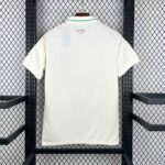 White polo shirt hanging on a hanger, back view with a small Cymru crest near the collar.