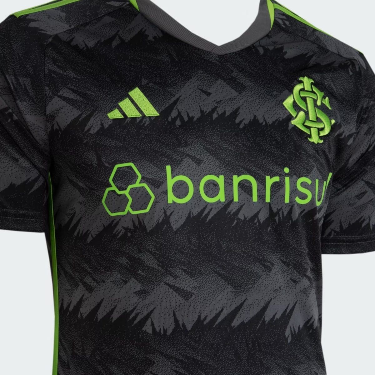 Black camouflage soccer jersey with neon-green branding: Adidas logo on the left and a neon club crest on the right, bold neon 'banrisul' sponsor across the chest.