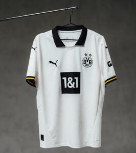 White Borussia Dortmund soccer jersey on a hanger, black collar, BVB crest with two gold stars, and 1&1 sponsor on the front.