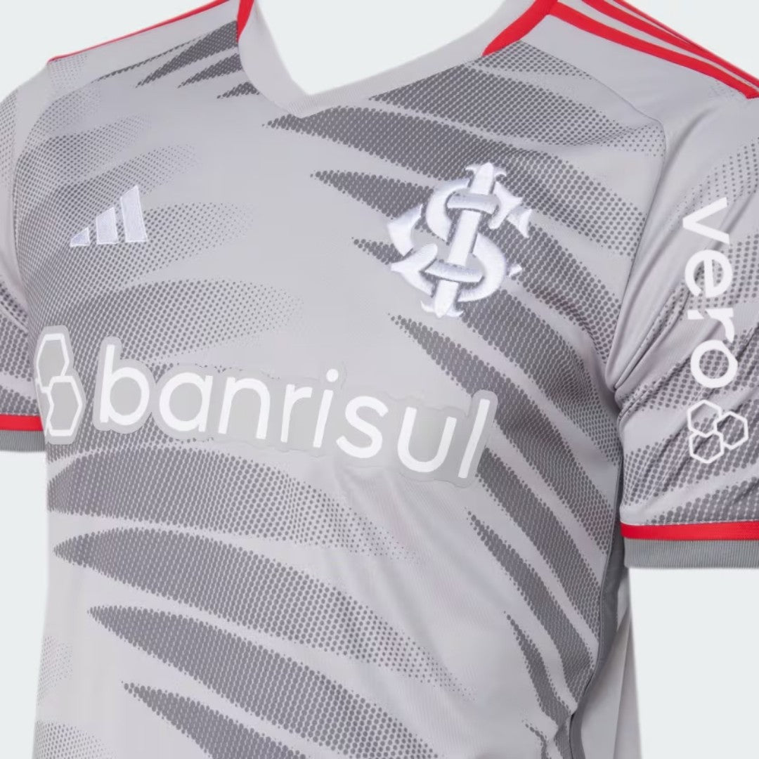 9VdAaPKelj7mFaK | UAE SPORT STORE Gray sports jersey with diagonal dot pattern, red trim, Adidas logo on the left chest, white 'banrisul' sponsor text across the front, and a crest near the shoulder.