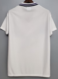 White polo shirt shown from the back, hanging on a hanger, with a navy striped collar