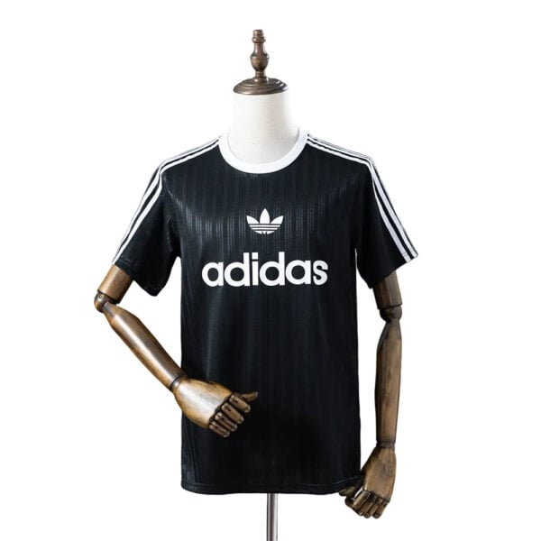 Black Adidas T-shirt with white logo and three stripes on sleeves displayed on a mannequin.