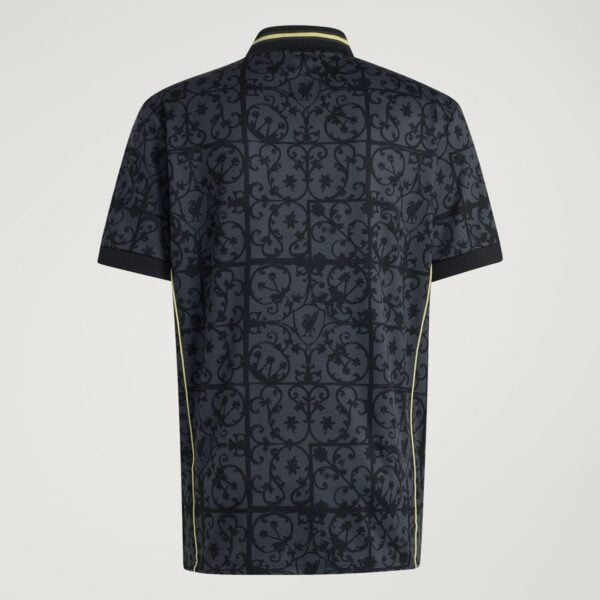 Back view of a dark polo shirt with an ornate floral lattice pattern and pale-yellow piping along the seams and collar edge.