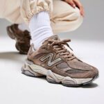 Brown suede and mesh sneaker with white sock, shown in a close-up on a white floor