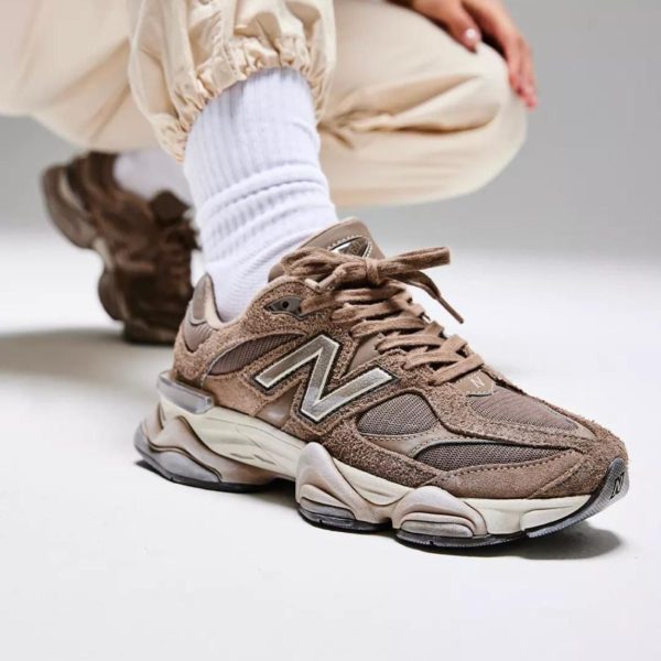Brown suede and mesh sneaker with white sock, shown in a close-up on a white floor