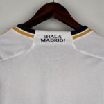 White textured sports jersey on a wooden hanger, with the text '¡HALA MADRID!' visible near the neckline.