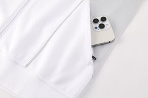 White jacket with a zip pocket holding a smartphone partially tucked into a gray sleeve pocket