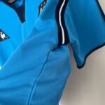 Close-up of bright blue mesh fabric with a black zipper and white trim on a sports jacket.