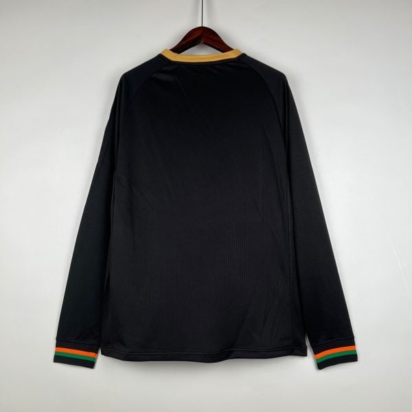 Black long-sleeve shirt on a wooden hanger, orange and green striped cuffs visible at the sleeves.