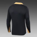 Back view of a black long-sleeve polo shirt with camel-colored collar and sleeve accents.