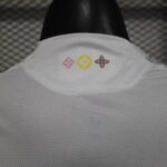 White mesh collar with three small decorative logos in pink, yellow, and pink placed along the back edge of the garment