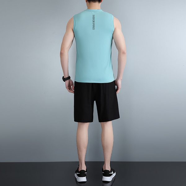 Back view of a person in a mint sleeveless athletic shirt and black shorts, standing against a gray wall.