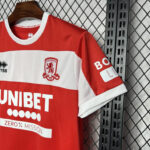 Red and white football jersey on a wooden hanger in a metal locker, showing the UNIBET sponsor and club crest.