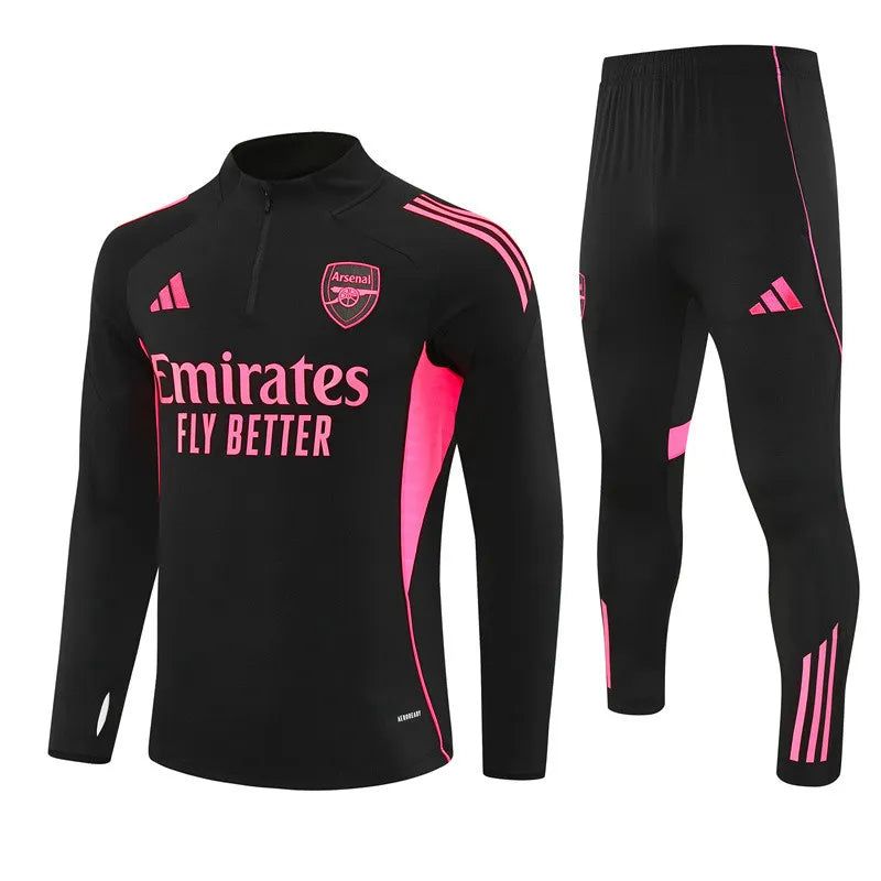 9f31f80e-29f5-4edf-b927-36bb5ec70c14 Black Arsenal training kit with pink accents: long-sleeve top with Emirates Fly Better slogan and crest, plus matching black pants with pink stripes. Option 2: Arsenal football club training gear: black jersey with pink trim and logo, and black pants with pink detailing. Option 3: Athletic training set in black with hot-pink panels, Arsenal crest, Emirates Fly Better text on top, and matching pants with pink stripes.