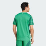 Back view of a man wearing a bright green athletic jersey, standing against a light background.