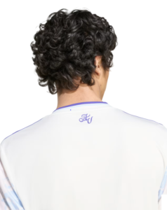 Back view of a person with curly dark hair wearing a white sports jersey with purple trim and initials 'HW' on the collar.