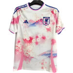 White Japan national football team jersey with pink floral pattern and blue accents on the shoulders and collar