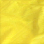 Close-up of bright yellow fabric with soft folds and visible stitching suggests textile texture.