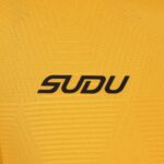 Close-up of yellow knitted fabric featuring a black 'SODU' logo.
