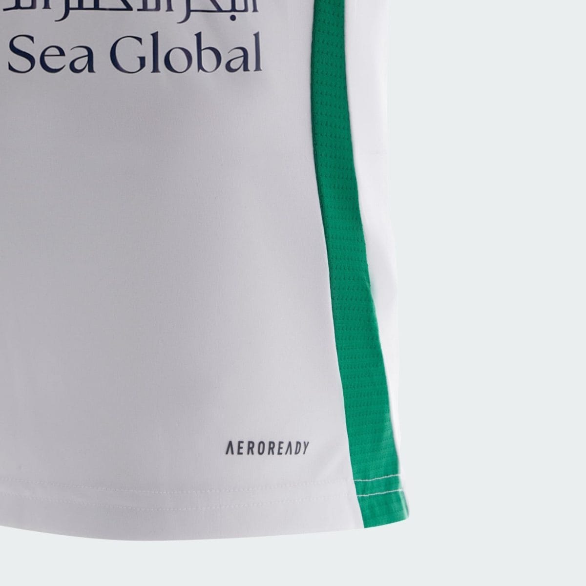 Close-up of white athletic fabric with a green vertical stripe along the side and the 'AEROREADY' branding near the hem.