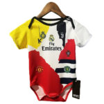 Baby onesie with a colorful football jersey collage, showing club crests (Real Madrid, Manchester United) and 'Fly Emirates'.
