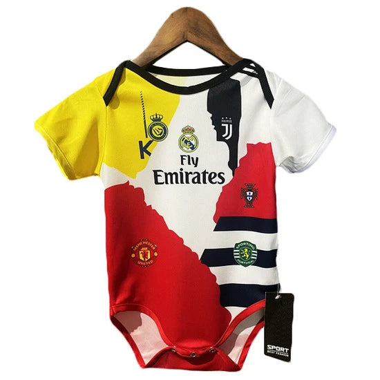 Baby onesie with a colorful football jersey collage, showing club crests (Real Madrid, Manchester United) and 'Fly Emirates'.