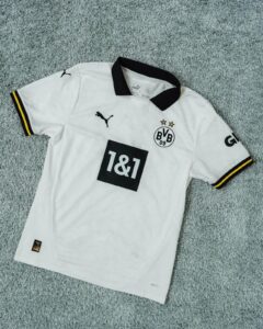 White Borussia Dortmund football jersey with black collar, featuring the BVB badge with two stars and sponsor '1&1' on the front.