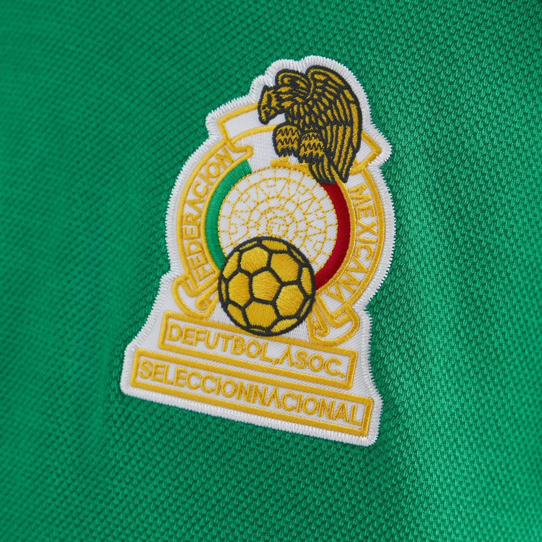 C3DEB1F8-3F8E-4B16-ABD2-FA615951C140 | UAE SPORT STORE Close-up of an embroidered Mexican Football Federation crest on a green jersey fabric.