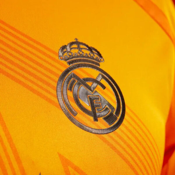 Embroidered Real Madrid crest on a bright yellow jersey with crown on top and circular emblem