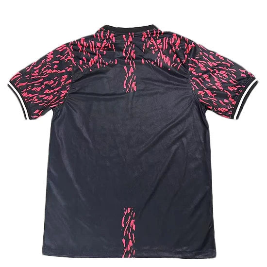Back view of a dark navy polo shirt with pink abstract pattern on the sleeves and a pink vertical stripe on the lower back area.