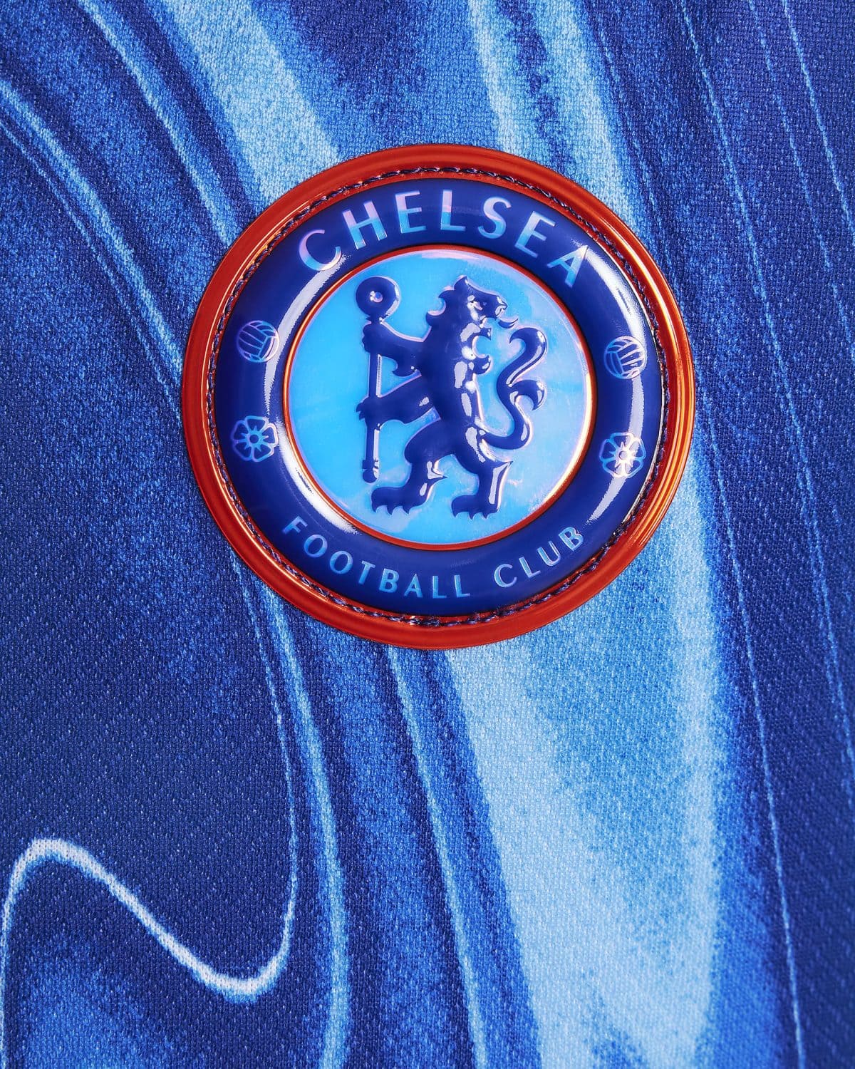 Chelsea Football Club crest on a blue textured background on fabric surface.