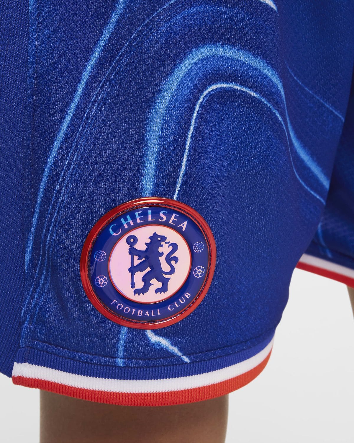 Close-up of the Chelsea FC badge on a blue jersey with red trim.ens