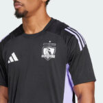 Close-up of a man wearing a black Colo-Colo football jersey with a crest on the chest.