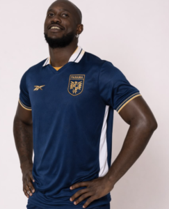 Athlete wearing a blue Panama national team soccer jersey with gold trim, standing with hands on hips against a light background.