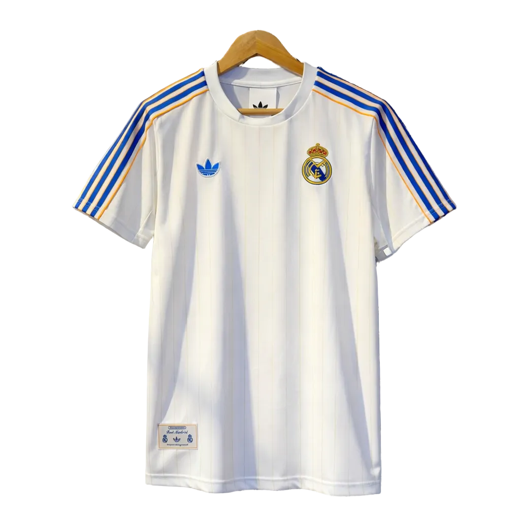 ChatGPT_Image_Dec_16_2025_11_47_43_PM | UAE SPORT STORE White Real Madrid soccer jersey with blue and gold stripes on the shoulders, Adidas logo on left chest and Real Madrid crest on right chest
